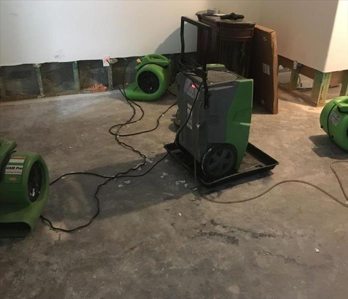 Bright green Servpro equipment drying a water damage.
